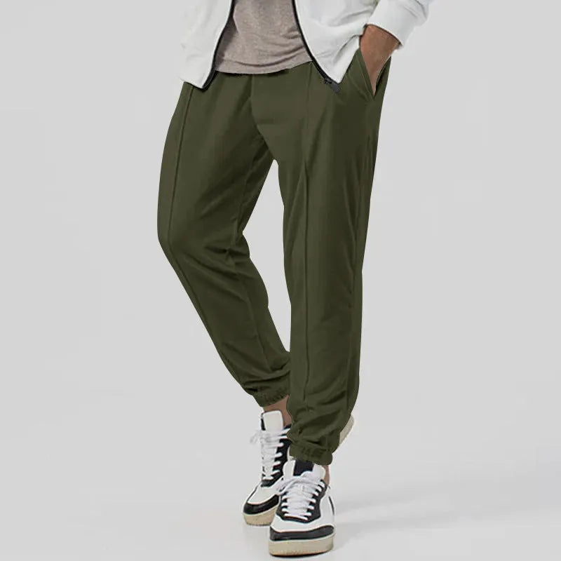 Man wearing gray straight-leg casual track sweatpants with a tapered fit and elastic waistband.