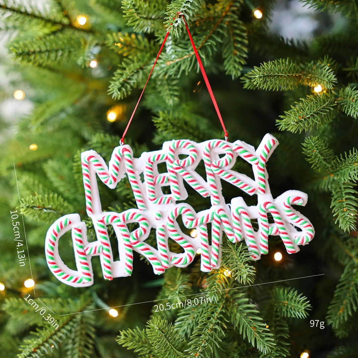 Merry Christmas letter plate polymer clay tree ornament in red, white and green plastic hanging on a tree branch