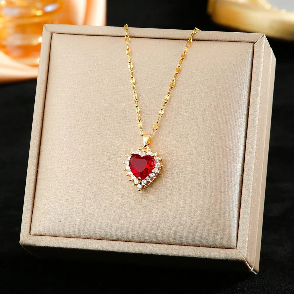 Gold red titanium steel necklace, earrings, and ring set with heart flower pendants and gem inlays.
