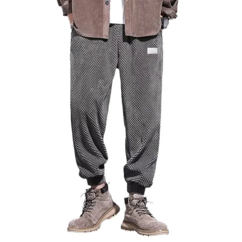 Men's grey ankle-tied straight-leg sweatpants laid flat, showing the tapered cut and tie detail.