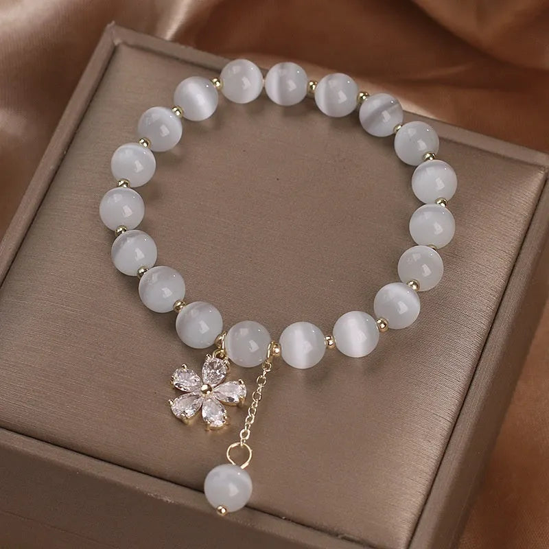 White cat's eye crystal bracelet with flower tassel charm and safety buckle closure