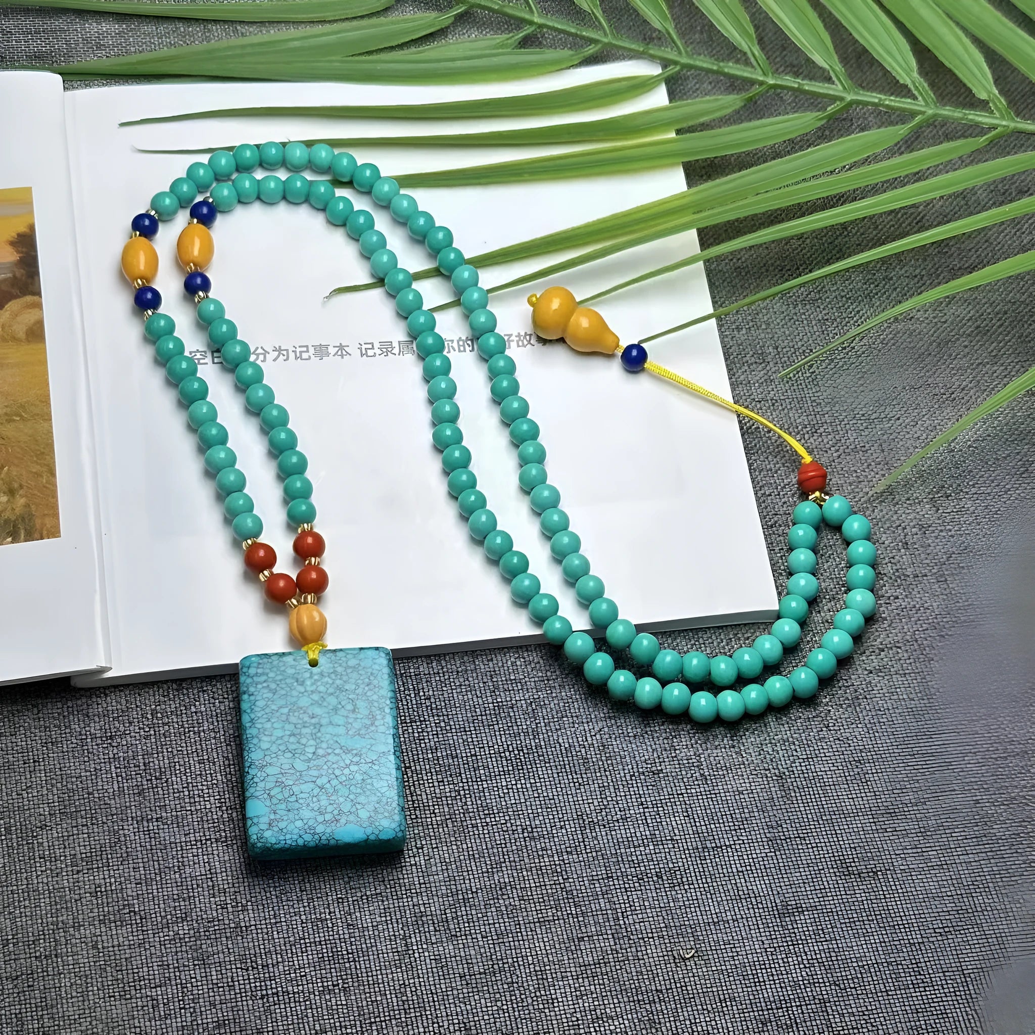 Turquoise stone pendant with hand-woven mesh flower design on adjustable ball bead necklace chain