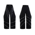 Men's black and white deconstructed trousers with metal striped rivets and front pleats.