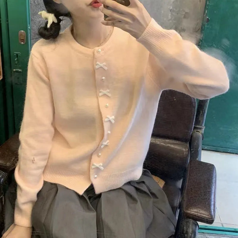 Women's solid colour cardigan with bow and pearl buttons, cashmere acrylic blend, shown in multiple colour options.