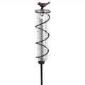 Cast iron outdoor rain gauge with glass hummingbird decoration showing measurement scale
