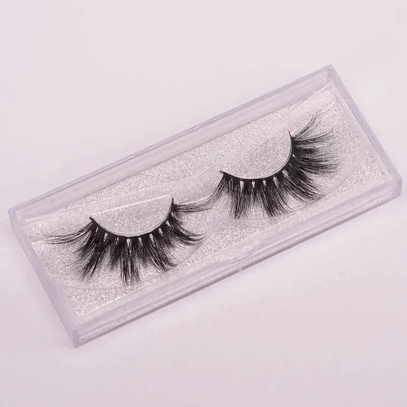 5D mink hair false eyelashes set with brush and storage cap on pink background.