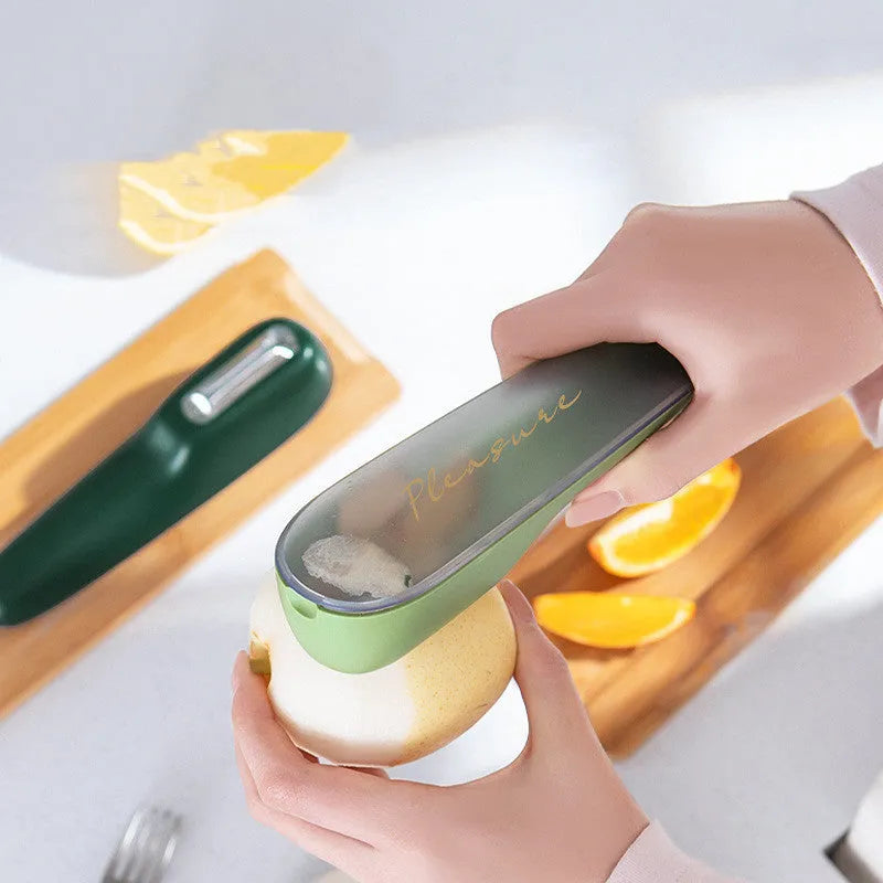 Green vegetable peeler with storage tube, non-slip handle, and hang hole on a kitchen worktop.