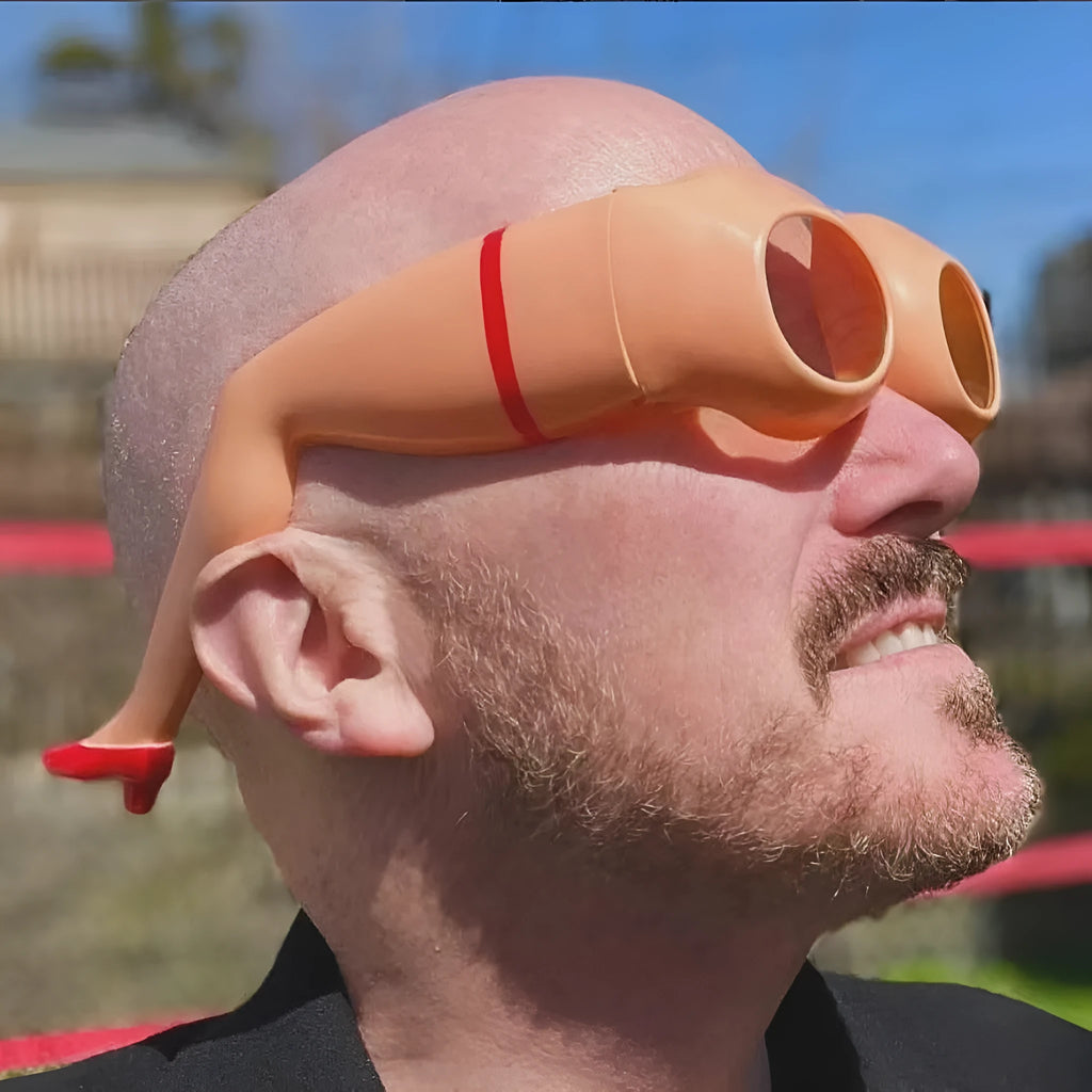 Orange plastic novelty sunglasses with leg and hip design on frame