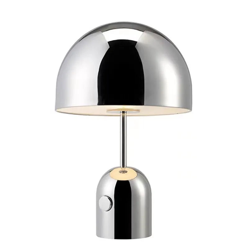 Mushroom-shaped metal table lamp in rose gold finish on wooden surface
