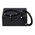 A pair of matching bracelets with polished geometric heart pendants made from natural stone.