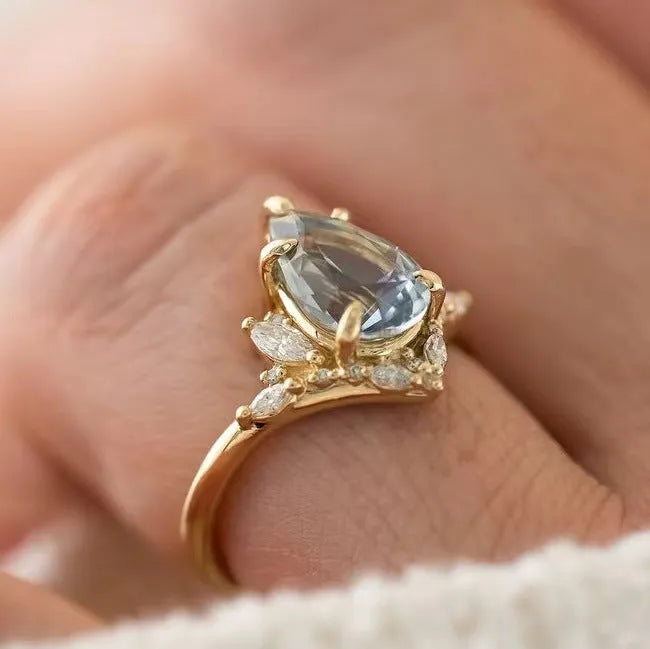 Gold alloy women's floral ring with blue crystal diamond inlay, side view