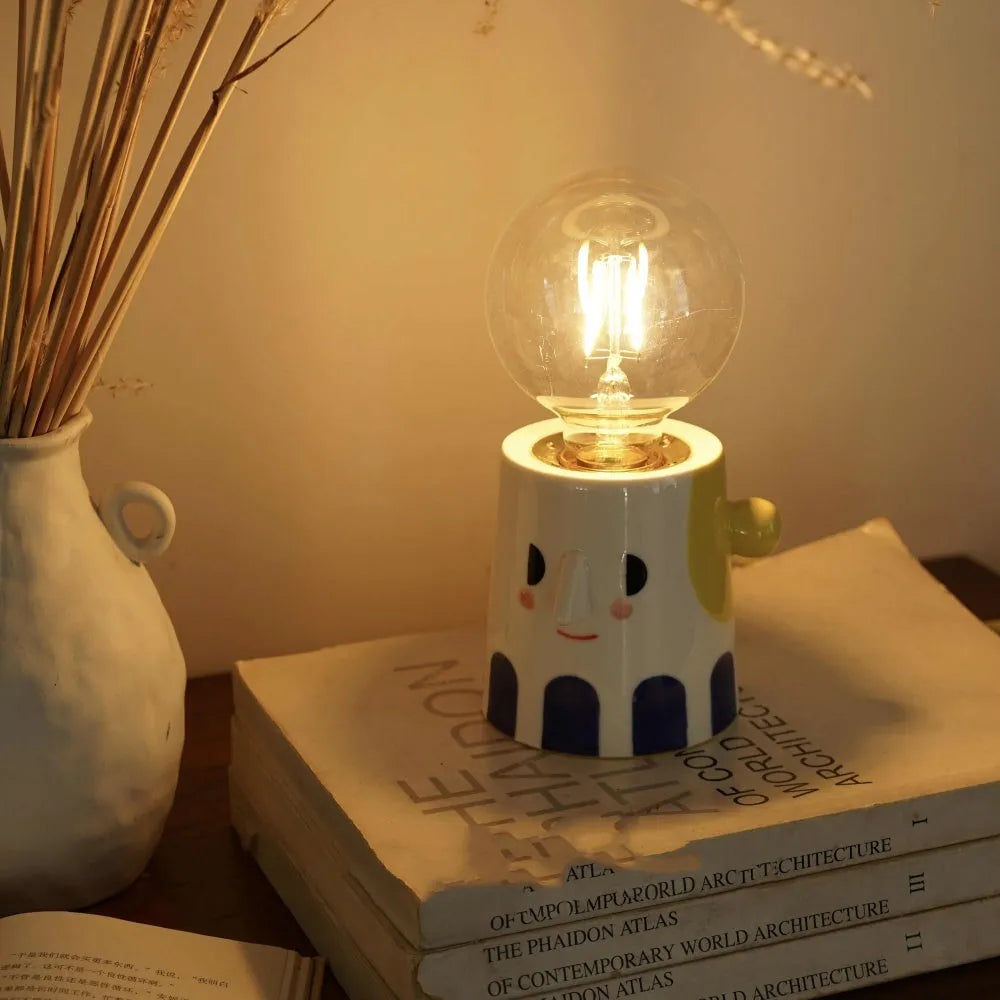 Handmade ceramic table lamp with ball headlight design on a bedside table