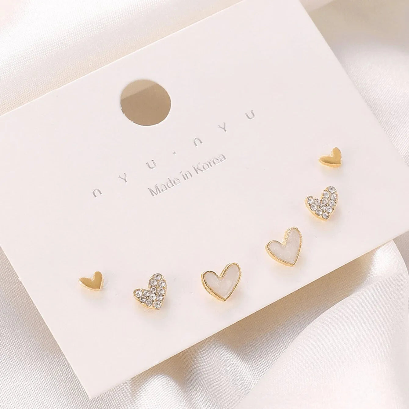 Women's heart-shaped earring set with three pairs in gold, black, black and white, and pink electroplated colours