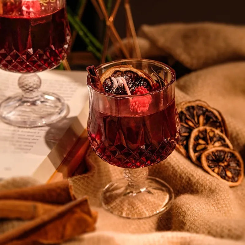 French mulled wine scented candle in a clear glass goblet on a table