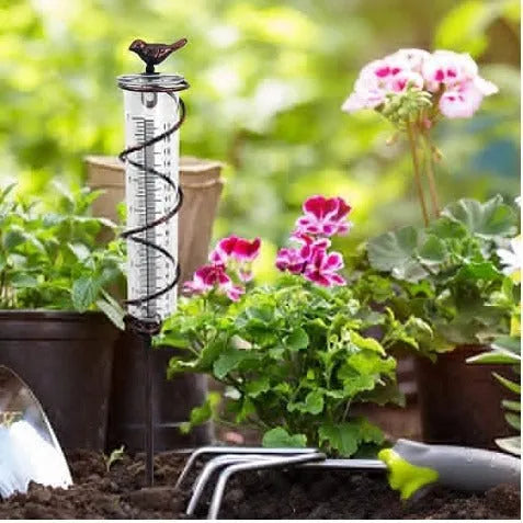 Cast iron outdoor rain gauge with glass hummingbird decoration showing measurement scale