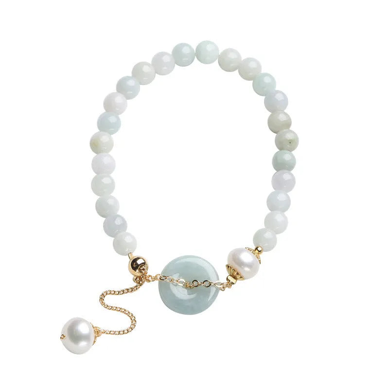 Jade green bracelet with peace buckle fastener and round pearl charms on wrist