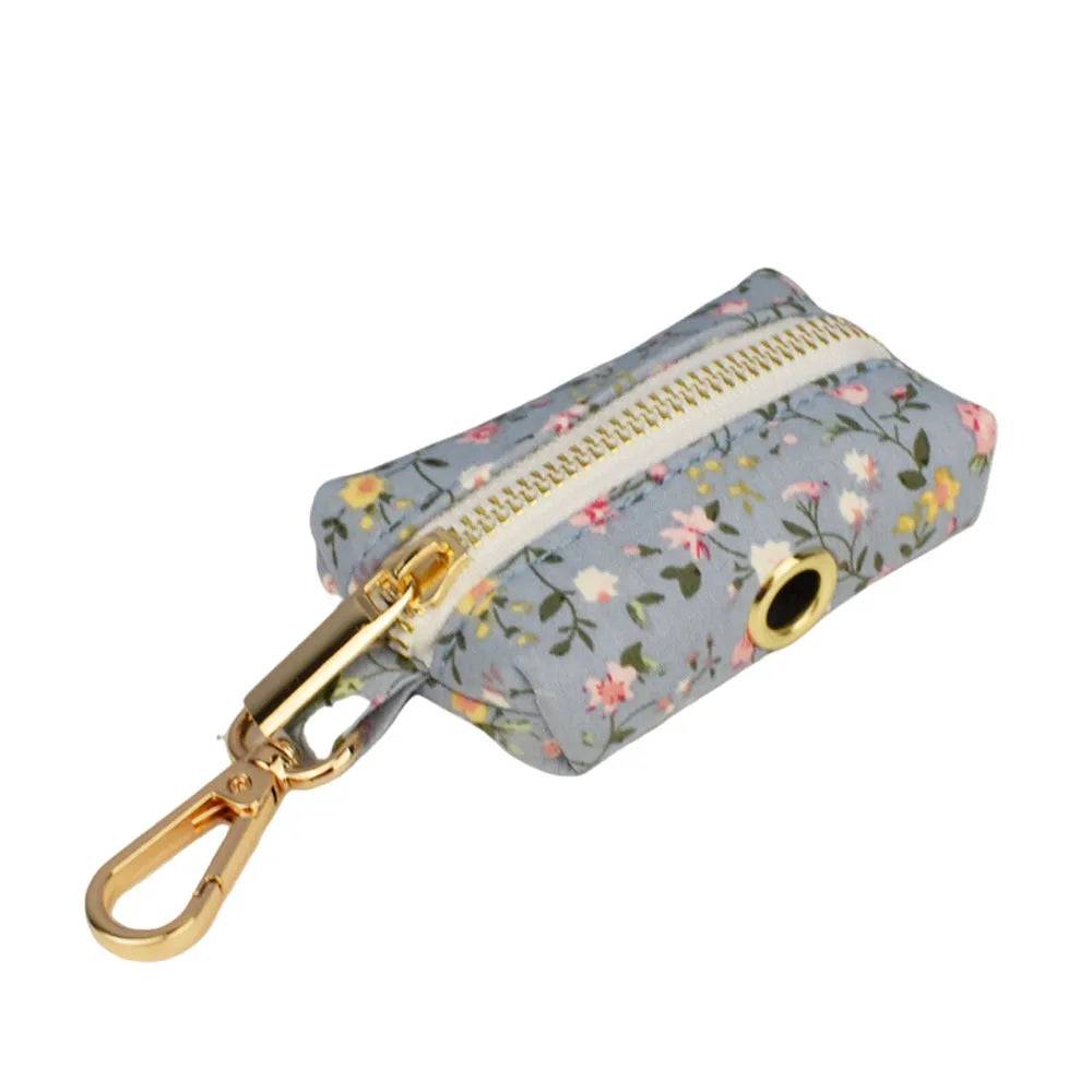 Blue floral patterned cloth dog collar and leash set with matching vest and bow accessories.
