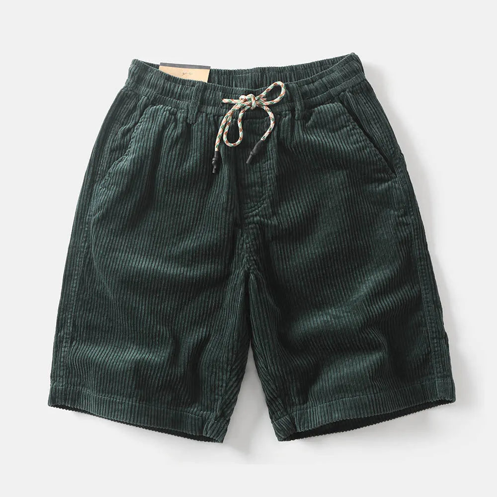 Men's khaki retro-style cargo shorts with a straight leg on a summer streetwear background.