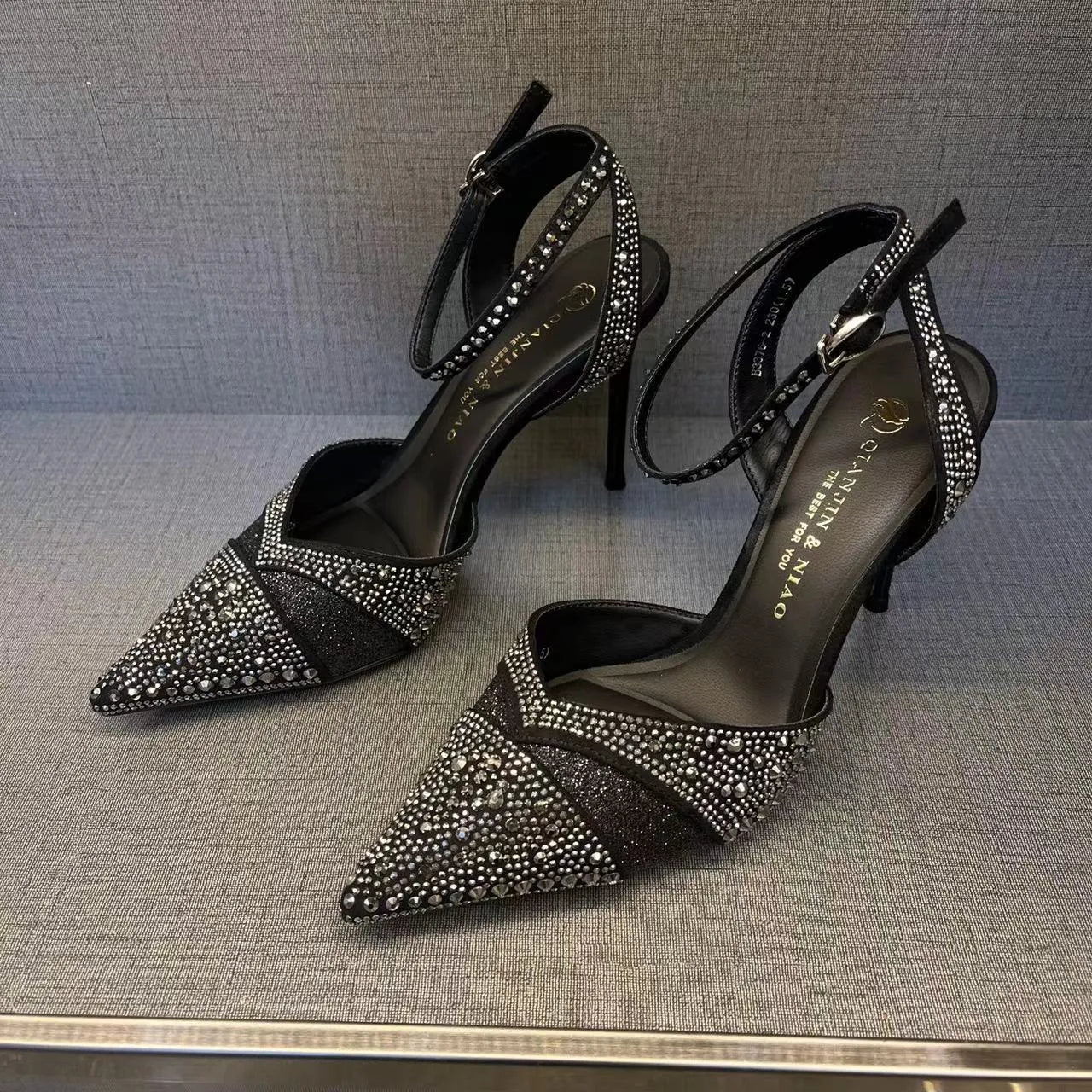 Women's black and silver hollow high heels with red soles, stiletto heels, and pointed toe design
