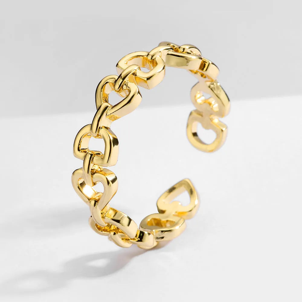 Minimalist Love Letter D geometric jewellery set including gold-plated earrings, ring, and bracelet on a light background