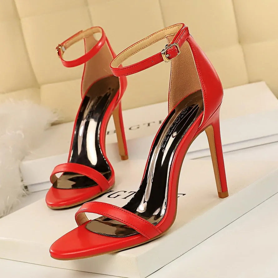 Women's ankle-strap high heel sandal in black with open toe and silver buckle.
