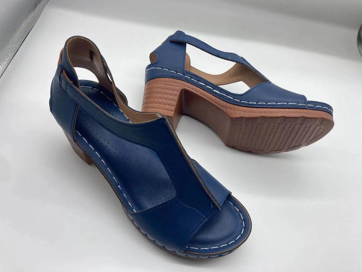Women's peep toe wedge sandals with buckle detail, low heel, on a white background.