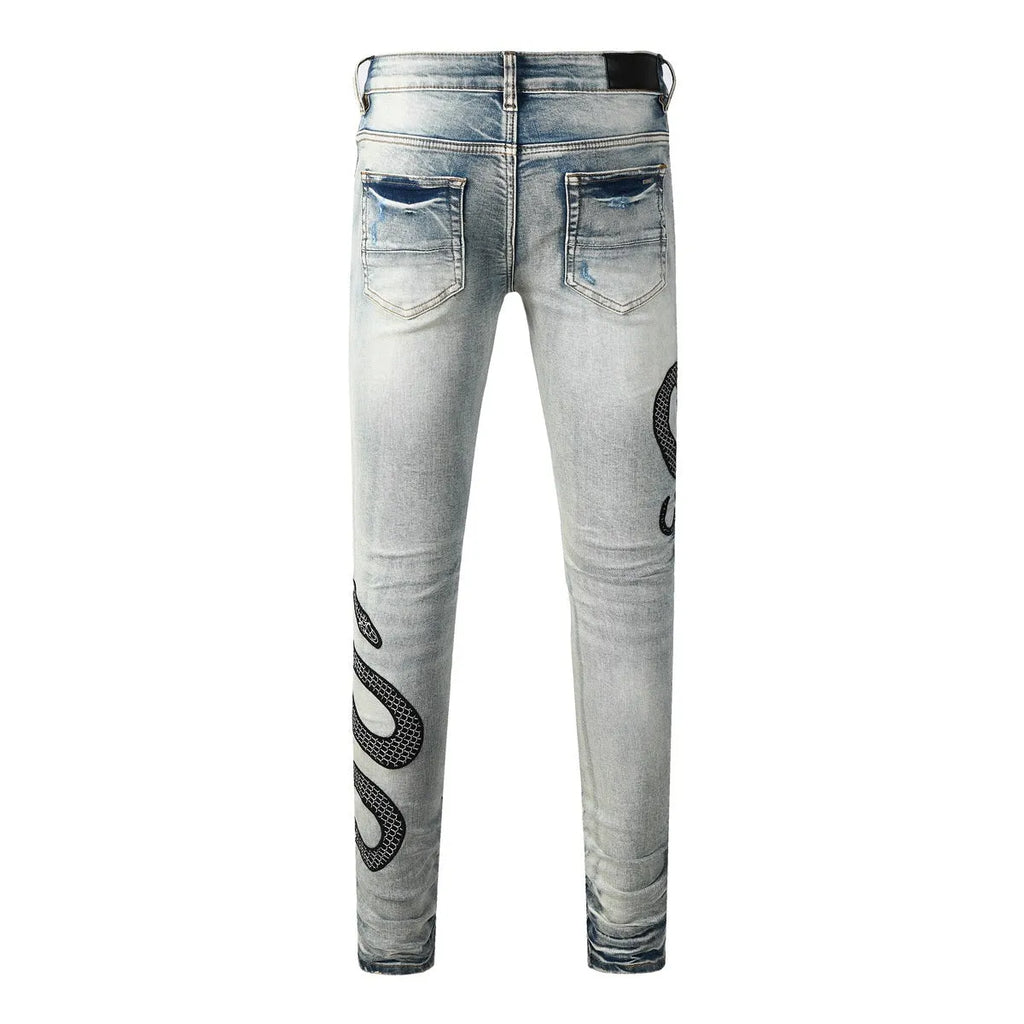 Close-up of wash distressed blue skinny jeans with a button fly and retro styling on a hanger.