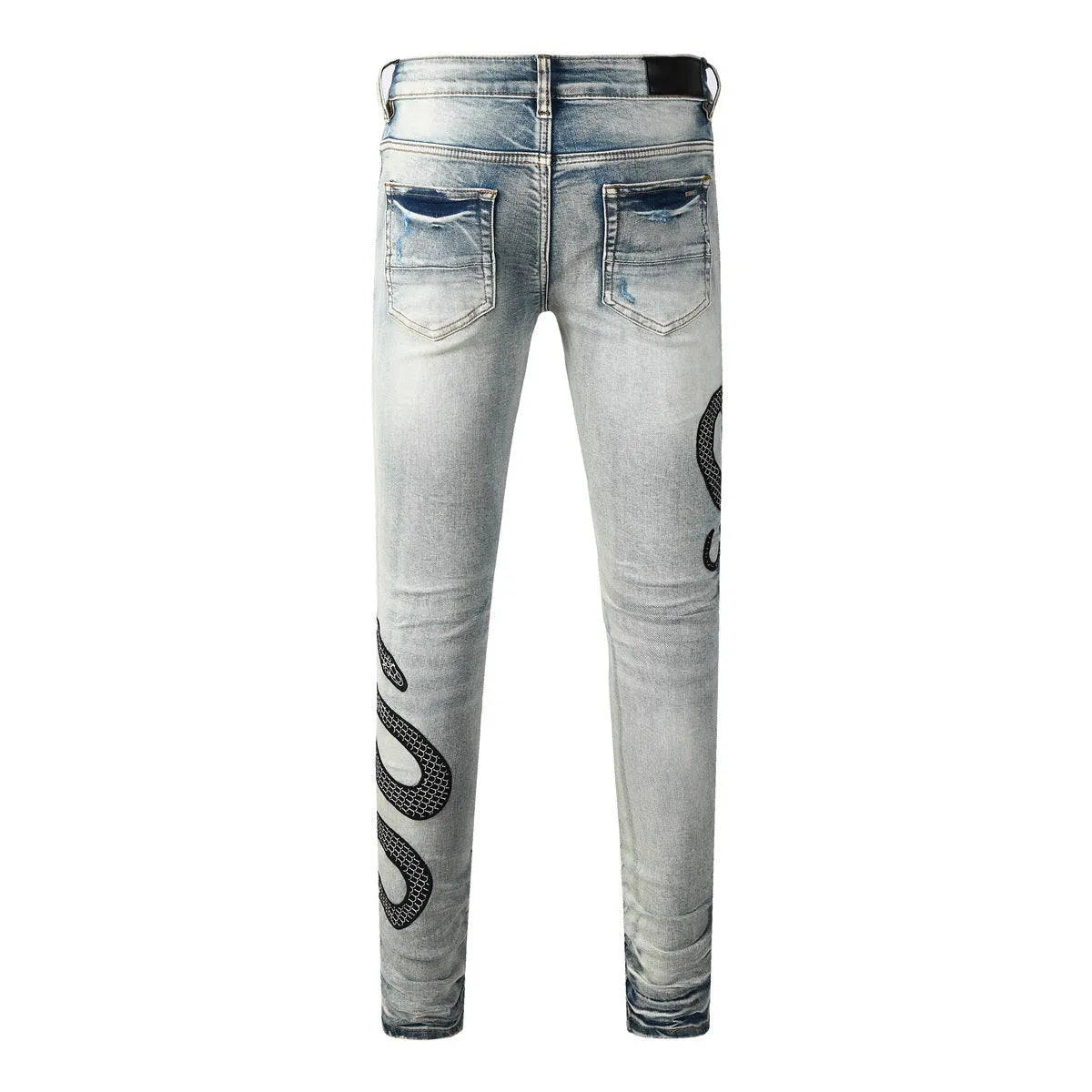 Close-up of wash distressed blue skinny jeans with a button fly and retro styling on a hanger.
