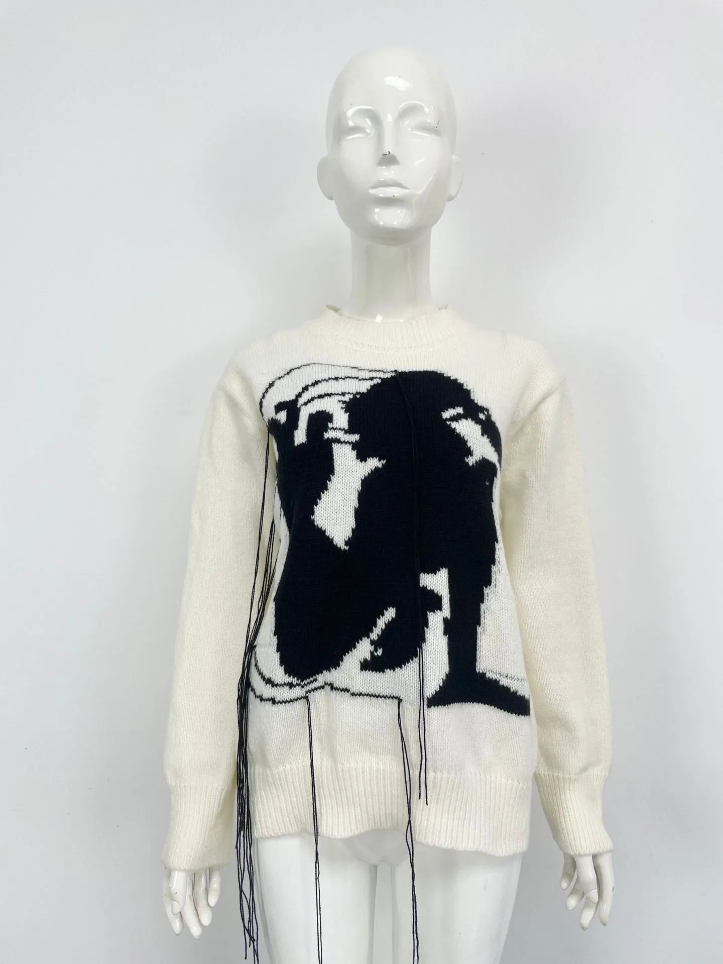 Women's grey alpaca wool sweater with tassel detailing and round neck.