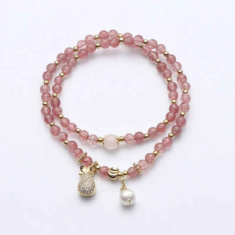 Geometric strawberry quartz crystal bracelet for women on a wrist.