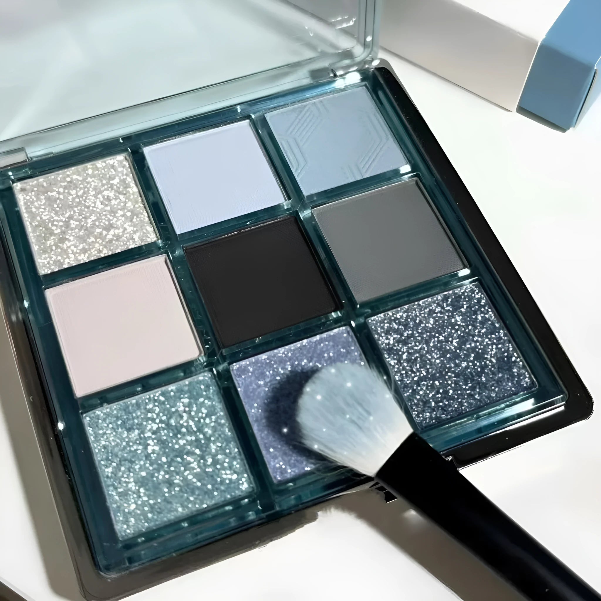 MUGELEEN nine-colour eye shadow palette showing matte and shimmer finishes in blue and smoked tones