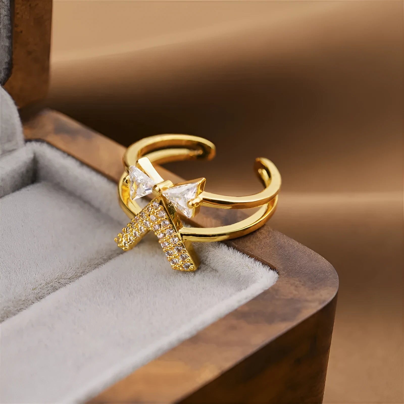 Gold geometric open ring for women on a grey background.
