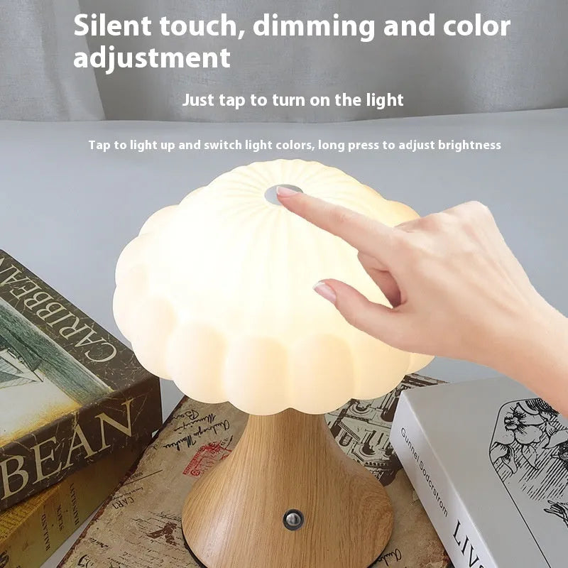 Small mushroom-shaped touch night lamp in wood grain finish on a wooden table.