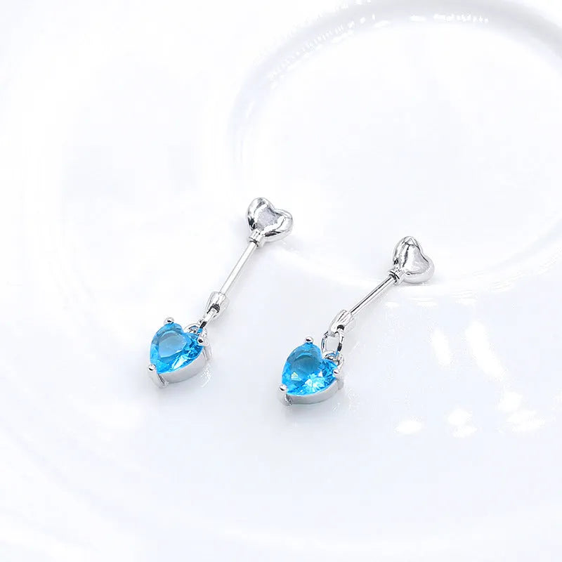 Copper heart shape fishtail earring with inlaid blue zirconium on light background