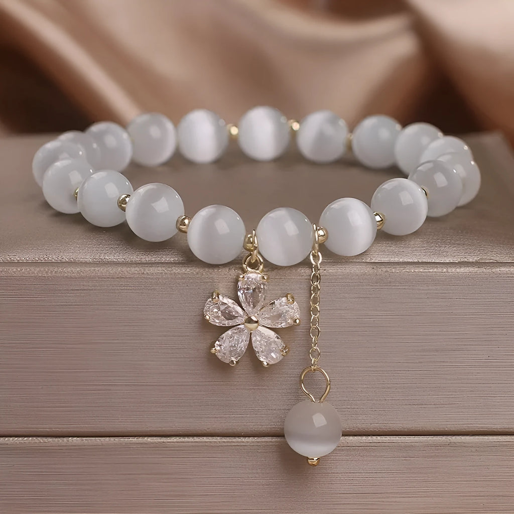 White cat's eye crystal bracelet with flower tassel charm and safety buckle closure