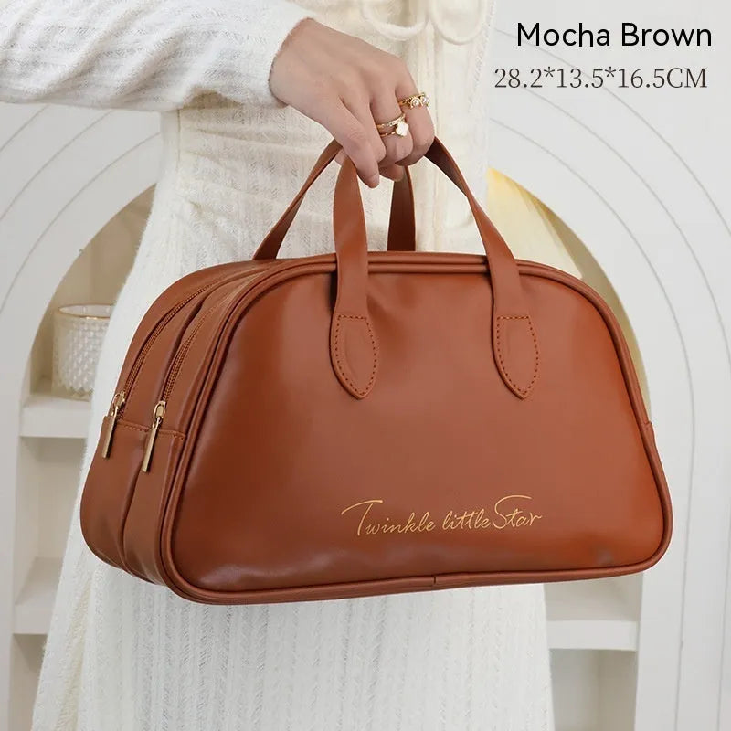 Large leather travel toiletry bag open to show dry and wet separation compartments.