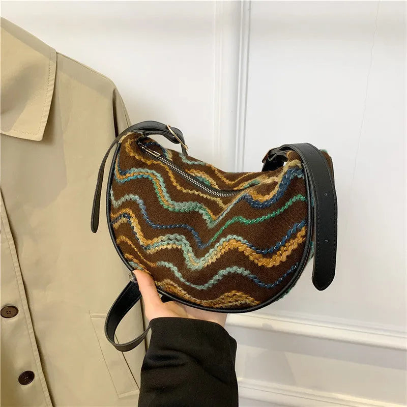 Women's knitted straw woven crossbody bag showing woven texture and internal phone compartment