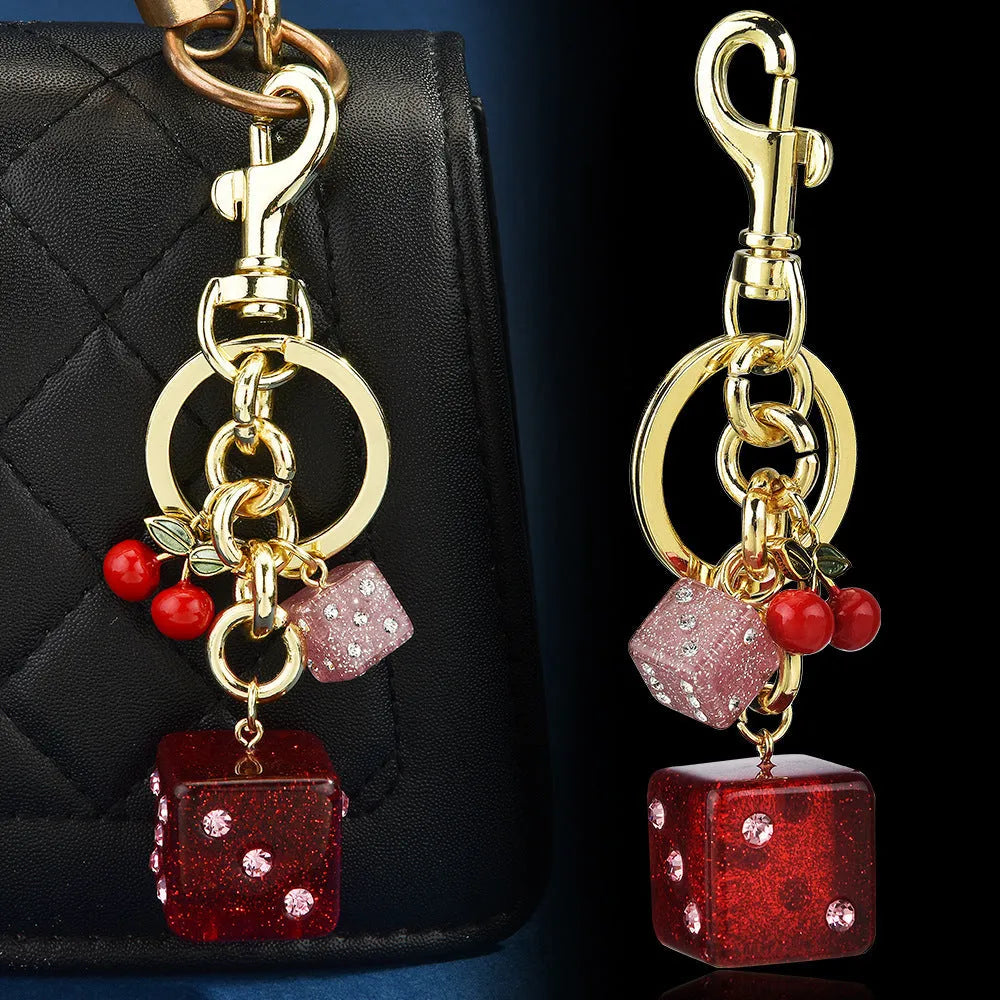 Square metal keychain pendant with cherry two-tone dice design and electroplated finish