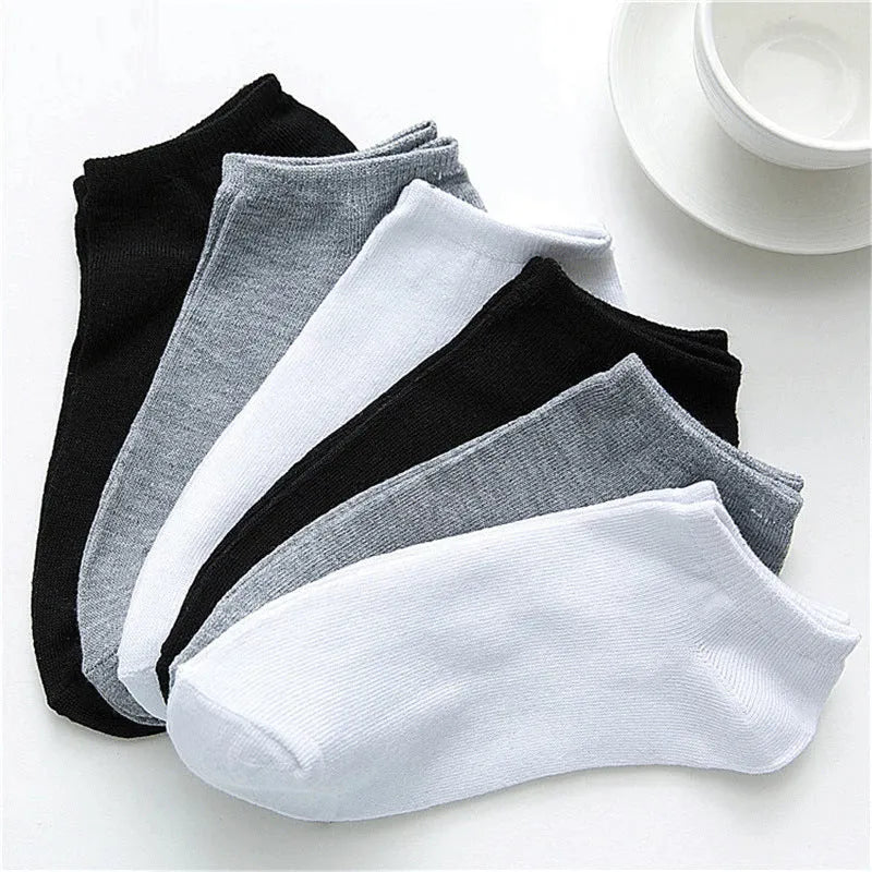 Solid colour men's low cut socks in black, grey, and white with seamless toe construction and blended fabric for breathability.