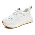 Beige women's leather casual sports shoes with low top, round toe, lace-up closure, and cross strap detail