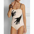 Women's one-piece bikini swimsuit with gauze skirt detail on beach