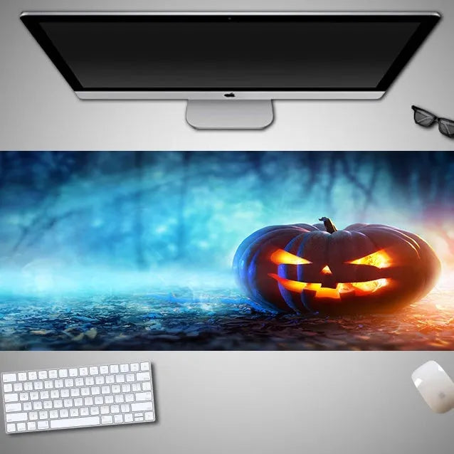 Oversized Halloween graphic cloth mouse pad on a desk, showing non-slip rubber base.