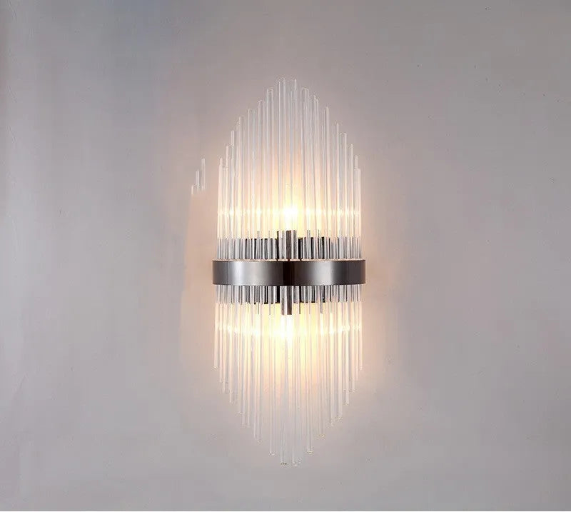 Modern crystal petal-shaped wall lamp in titanium gold finish mounted on a light-coloured wall.