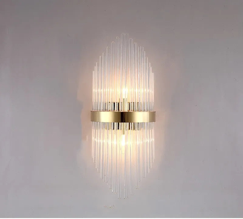 Modern crystal petal-shaped wall lamp in titanium gold finish mounted on a light-coloured wall.