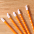 Pack of disposable lip brush applicators with coloured handles and flocked brush tips on a white background