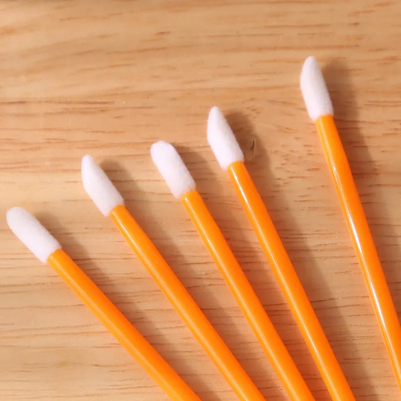 Pack of disposable lip brush applicators with coloured handles and flocked brush tips on a white background