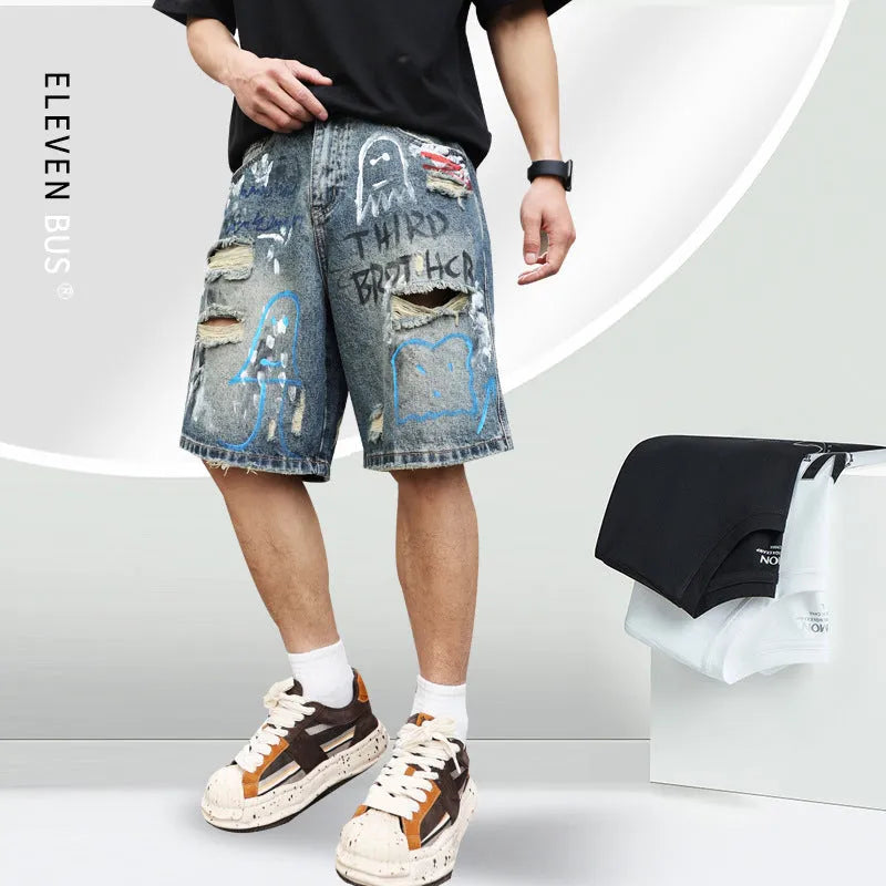 Men's blue ripped denim shorts with graffiti design and straight leg.