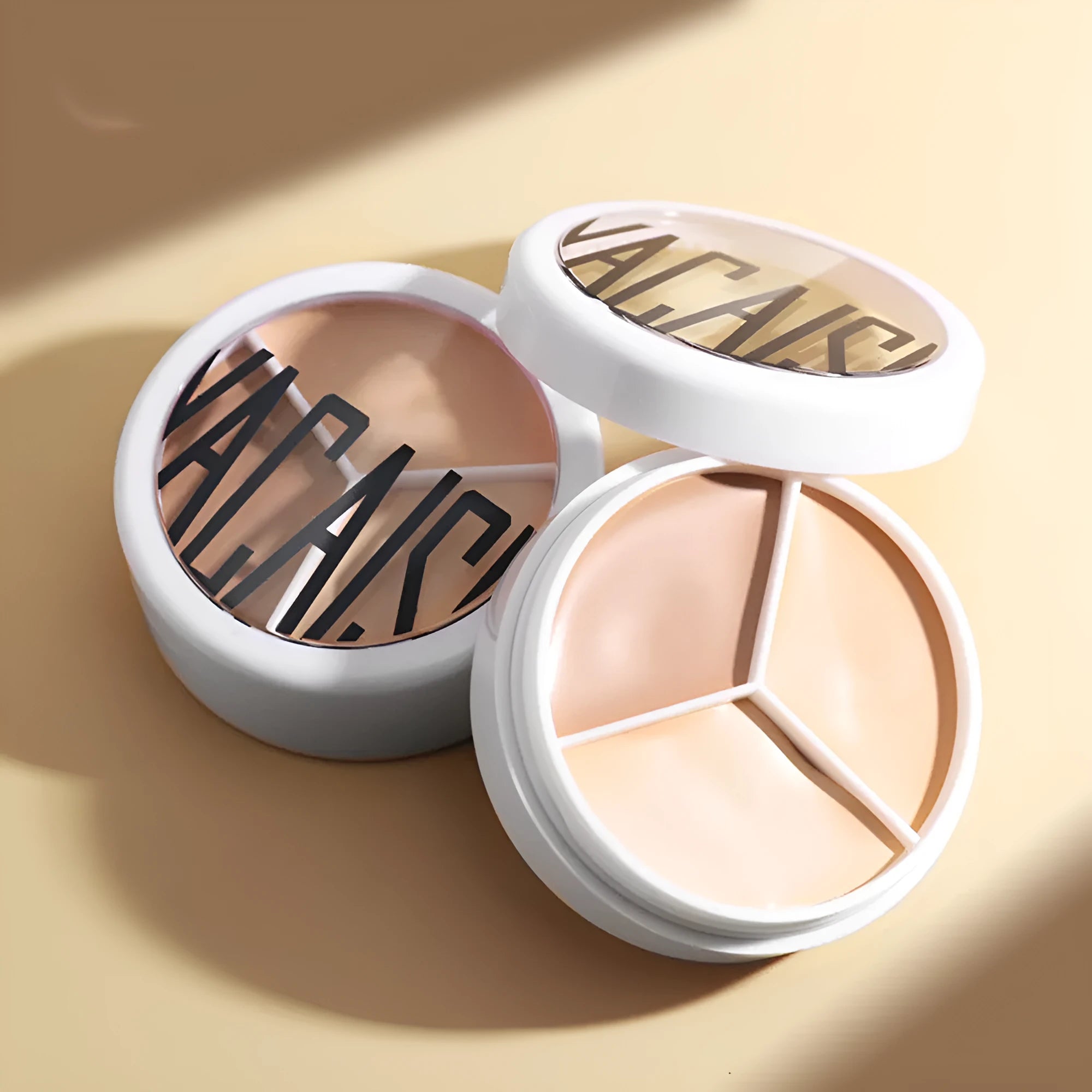 Three-colour waterproof concealer palette in ivory shade with optional brush for face application