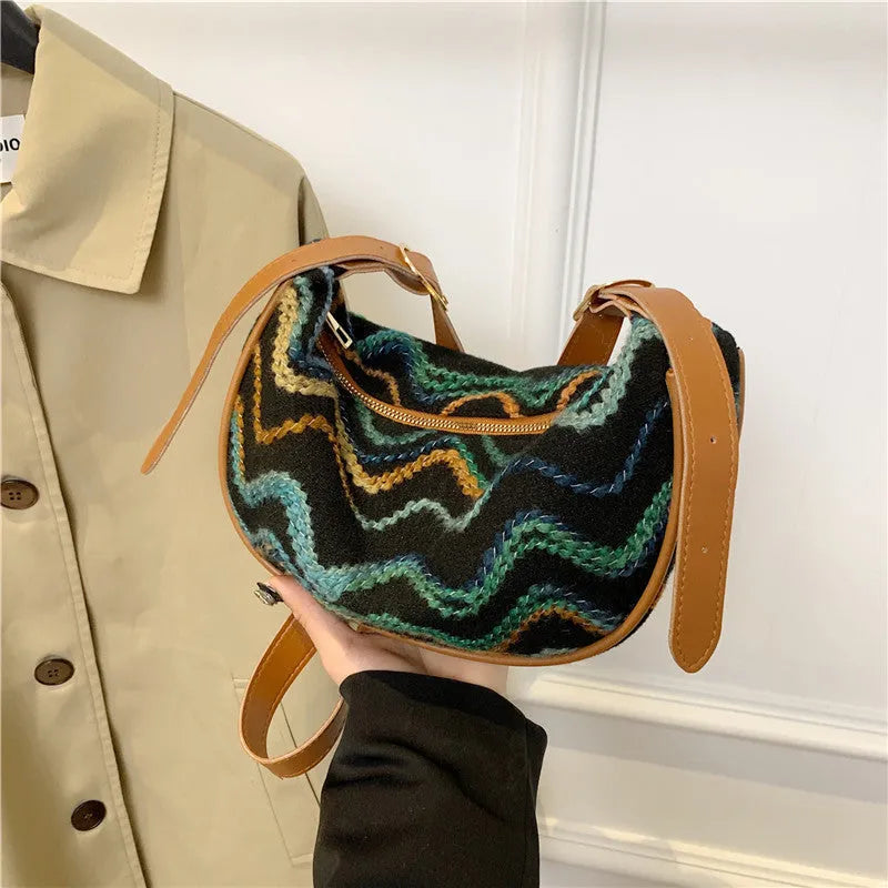Women's knitted straw woven crossbody bag showing woven texture and internal phone compartment