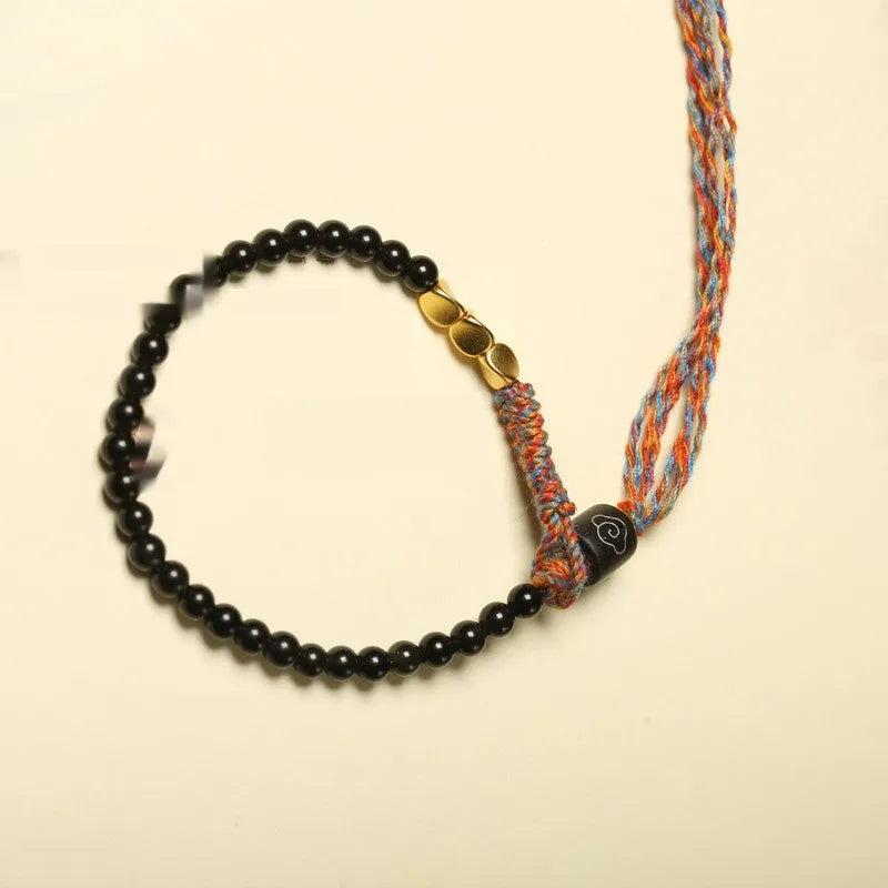 Hand-woven obsidian carrying strap bracelet showing textured weave detail and narrow 4mm width